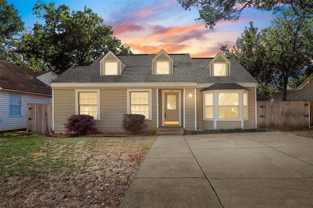 cape cod home with a lawn