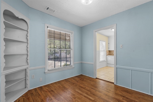 spare room with hardwood / wood-style floors and a textured ceiling