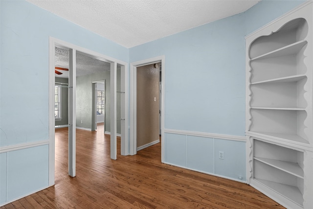 empty room with hardwood / wood-style floors and a textured ceiling