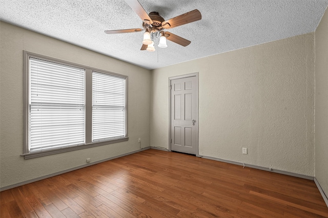 spare room featuring ceiling fan, wood-type flooring, and a textured ceiling