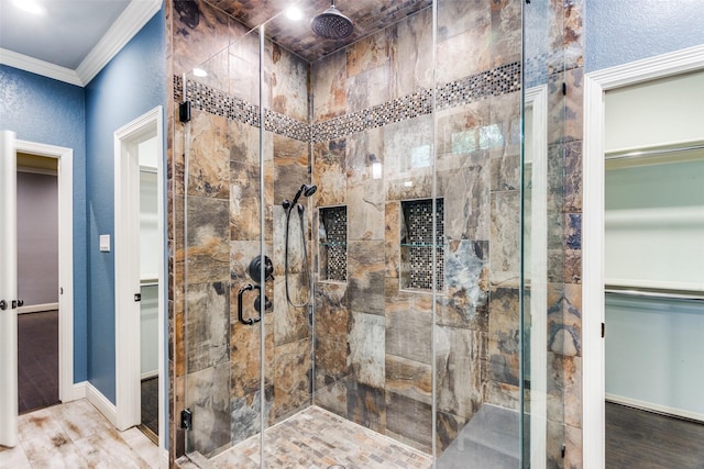 bathroom with a shower with shower door, wood-type flooring, and ornamental molding