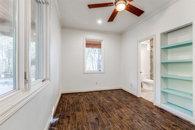 unfurnished room featuring ceiling fan, crown molding, dark hardwood / wood-style floors, and built in shelves