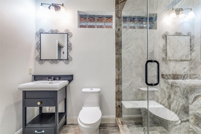 bathroom with vanity, hardwood / wood-style flooring, a shower with shower door, and toilet