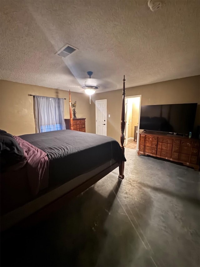 bedroom featuring ceiling fan, concrete flooring, and a textured ceiling