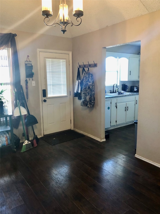 entryway with sink, dark hardwood / wood-style flooring, and an inviting chandelier