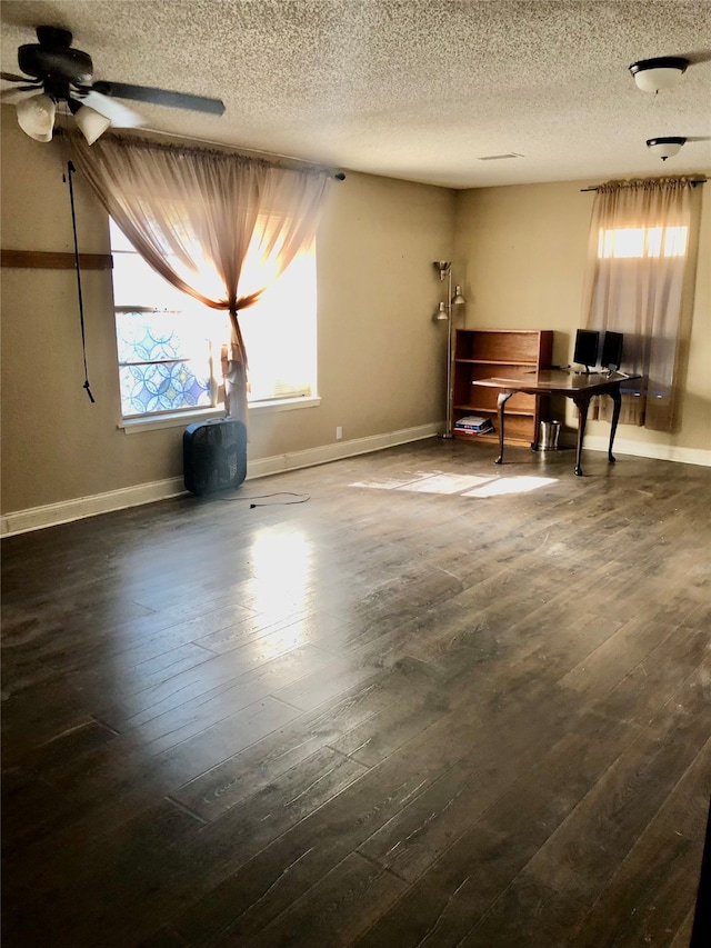 interior space featuring dark wood-type flooring, a textured ceiling, and ceiling fan