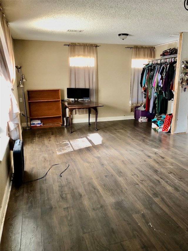 interior space featuring a textured ceiling and dark hardwood / wood-style floors