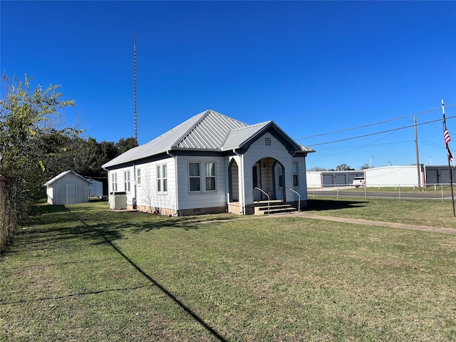 view of front of house featuring a shed, central AC, and a front yard