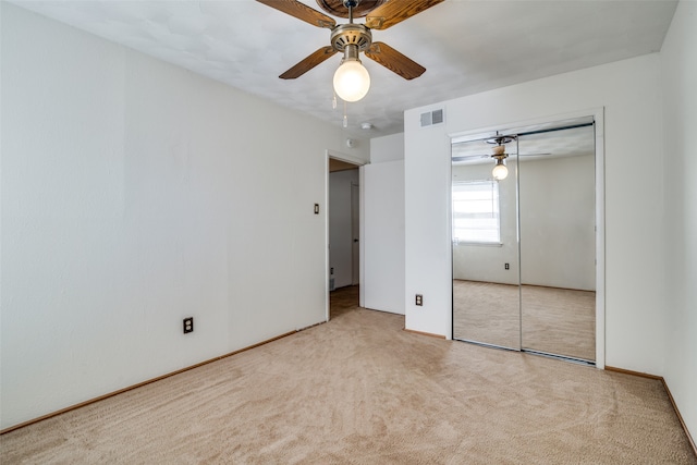 unfurnished bedroom with light carpet, a closet, and ceiling fan