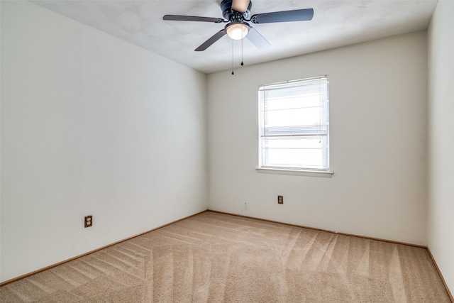 empty room featuring ceiling fan and light colored carpet