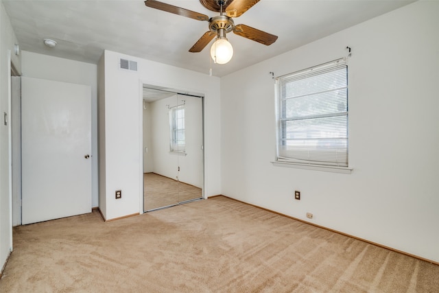 unfurnished bedroom with a closet, ceiling fan, and light colored carpet