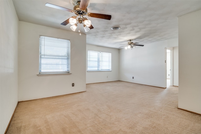 empty room featuring ceiling fan and light colored carpet