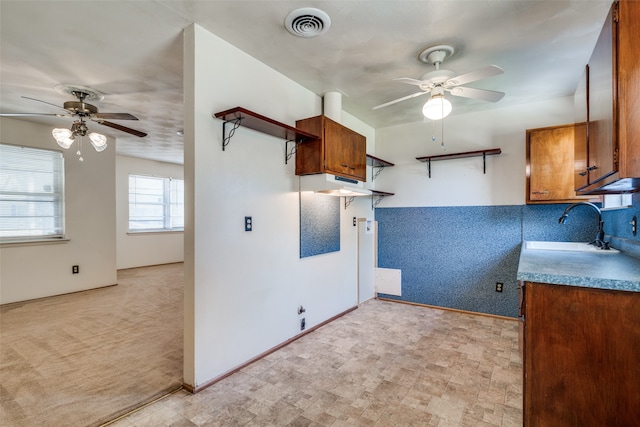 kitchen with light colored carpet, sink, and ceiling fan