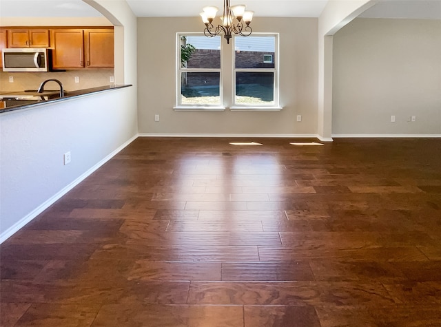 unfurnished dining area with dark hardwood / wood-style flooring and an inviting chandelier