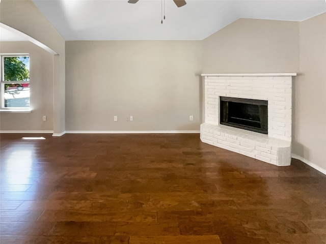 unfurnished living room with lofted ceiling, ceiling fan, a fireplace, and dark hardwood / wood-style flooring