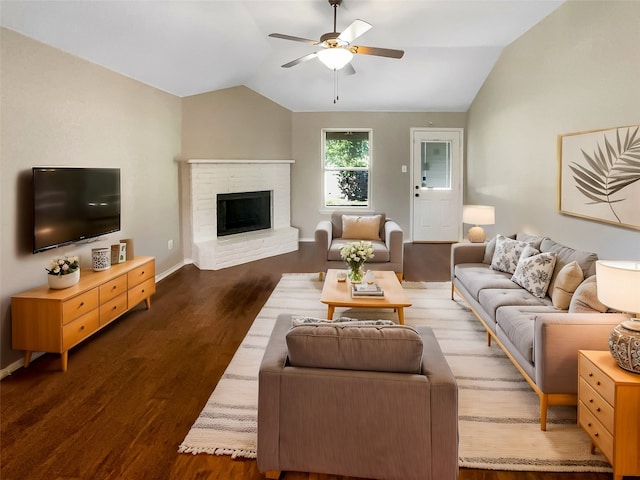 living room featuring lofted ceiling, dark wood-type flooring, a fireplace, and ceiling fan