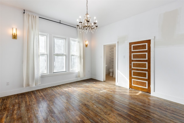 empty room featuring hardwood / wood-style flooring and a chandelier