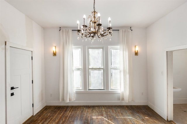 unfurnished dining area with a notable chandelier and dark hardwood / wood-style floors