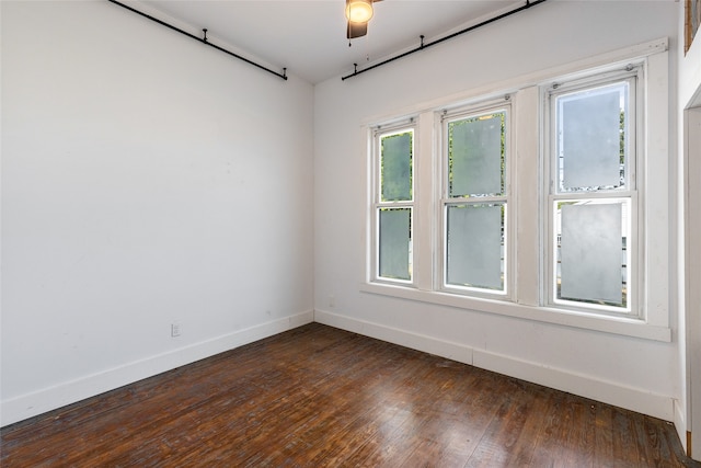 empty room featuring dark wood-type flooring and ceiling fan