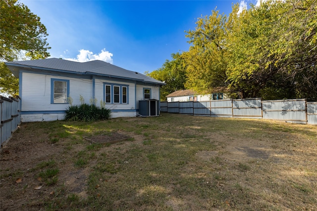 rear view of house with a yard and cooling unit