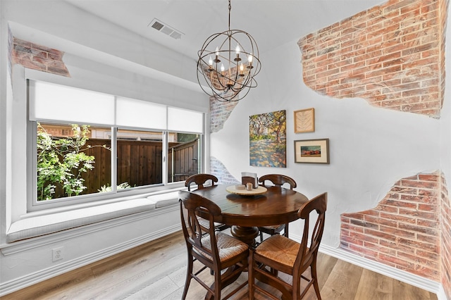 dining space featuring an inviting chandelier and light hardwood / wood-style floors