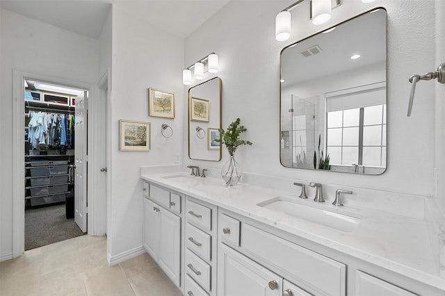 bathroom featuring vanity, a shower with shower door, and tile patterned flooring