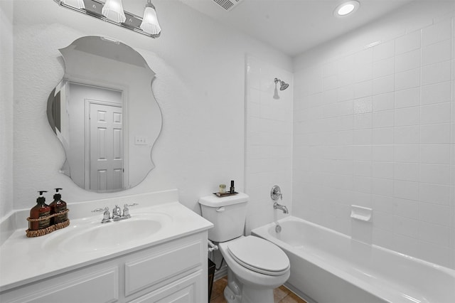 full bathroom featuring tiled shower / bath, vanity, and toilet