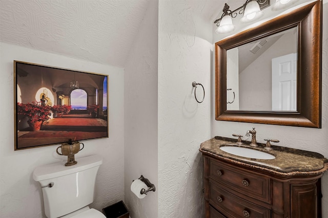 bathroom with vanity, a textured ceiling, and toilet