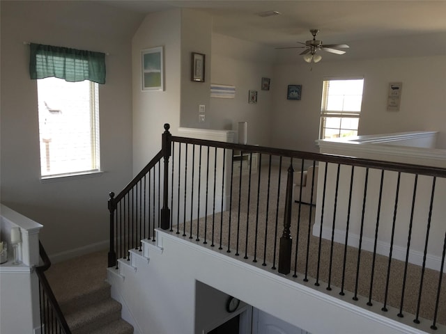 staircase with a healthy amount of sunlight and ceiling fan