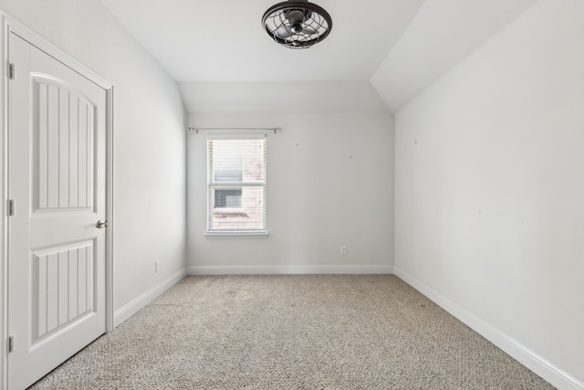 empty room with light carpet and vaulted ceiling