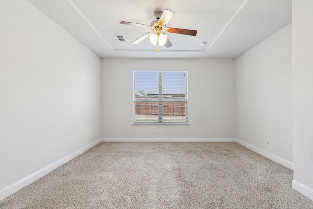 unfurnished room featuring ceiling fan, a raised ceiling, and carpet