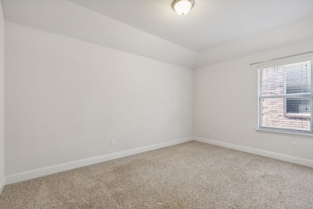 spare room with carpet and lofted ceiling