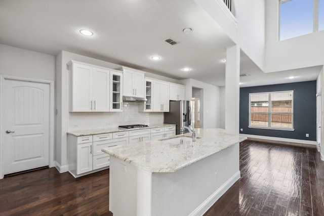 kitchen featuring white cabinetry, sink, backsplash, light stone counters, and stainless steel fridge with ice dispenser