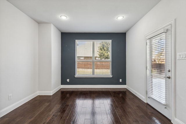 unfurnished room with dark hardwood / wood-style flooring