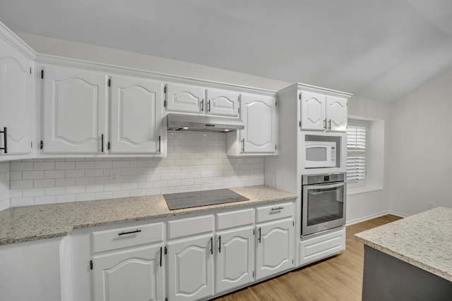 kitchen with stainless steel oven, backsplash, black electric stovetop, white cabinets, and light hardwood / wood-style flooring