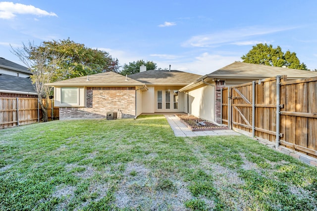 rear view of property featuring a lawn