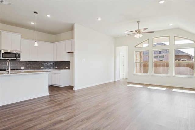 kitchen with white cabinets, pendant lighting, and light hardwood / wood-style floors