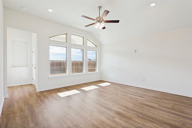 spare room with light hardwood / wood-style floors, ceiling fan, and lofted ceiling