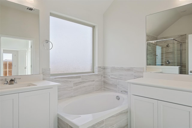 bathroom with lofted ceiling, vanity, and shower with separate bathtub