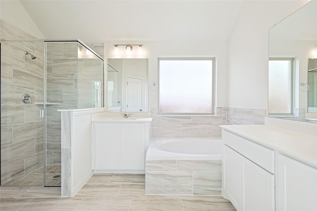 bathroom featuring lofted ceiling, shower with separate bathtub, and vanity