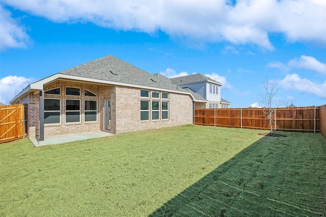 back of house with a patio area and a lawn