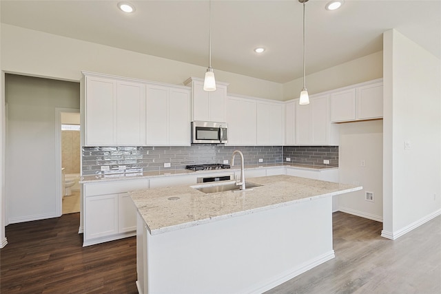 kitchen featuring sink, white cabinetry, and a center island with sink