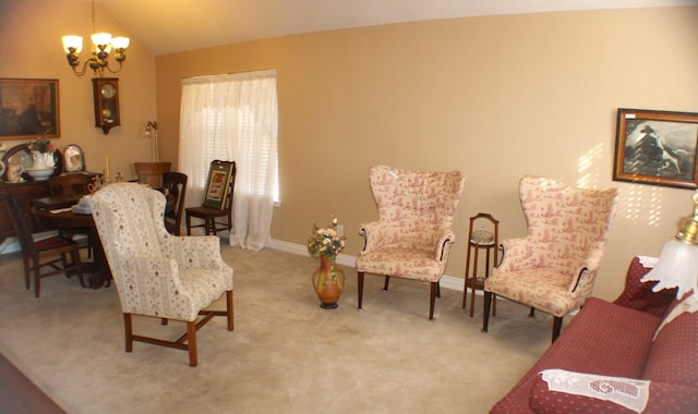 sitting room with a chandelier, carpet floors, vaulted ceiling, and baseboards