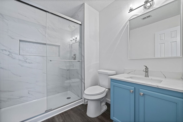 bathroom featuring vanity, toilet, hardwood / wood-style flooring, and a shower with shower door