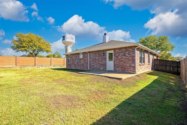 back of property with a patio area and a lawn