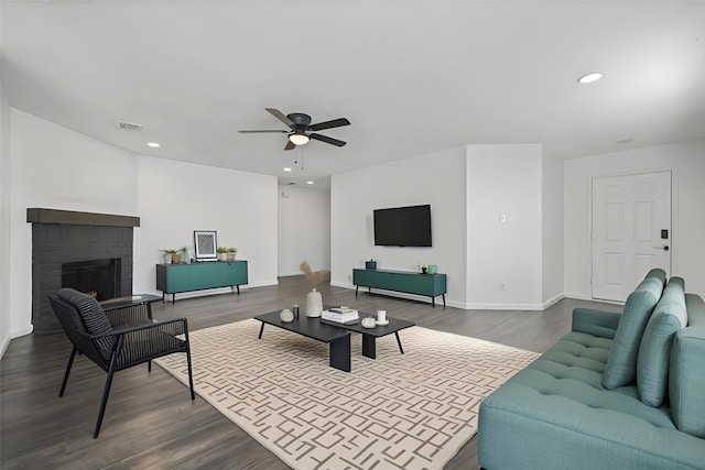 living room with a fireplace, dark hardwood / wood-style floors, and ceiling fan