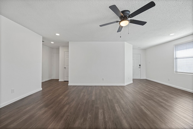 unfurnished living room with ceiling fan, a textured ceiling, and dark hardwood / wood-style floors