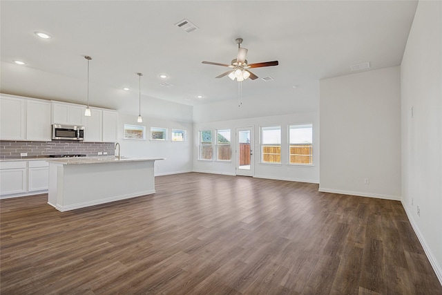 kitchen with white cabinetry, ceiling fan, tasteful backsplash, hanging light fixtures, and dark hardwood / wood-style flooring