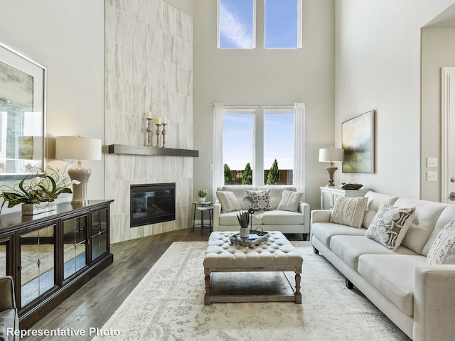 living room featuring a fireplace, a high ceiling, and dark hardwood / wood-style floors