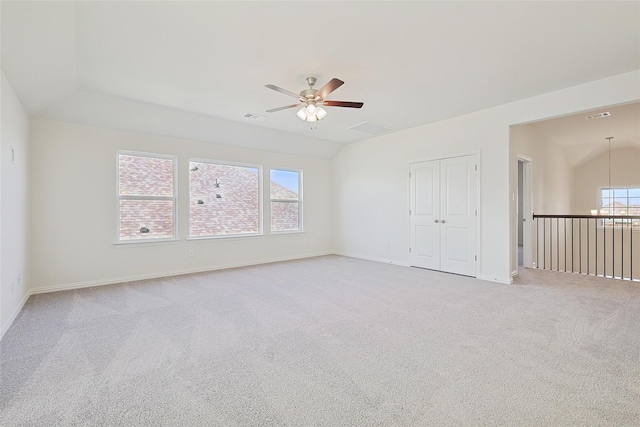 spare room with light carpet, a wealth of natural light, and ceiling fan